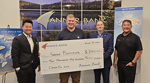 A man holding an oversized check next to three other men