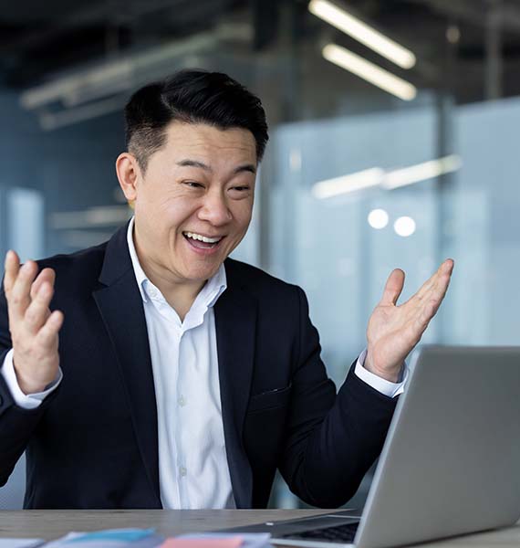 Person excited and looking at a laptop