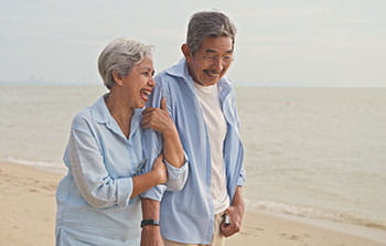 older couple walking on the beach
