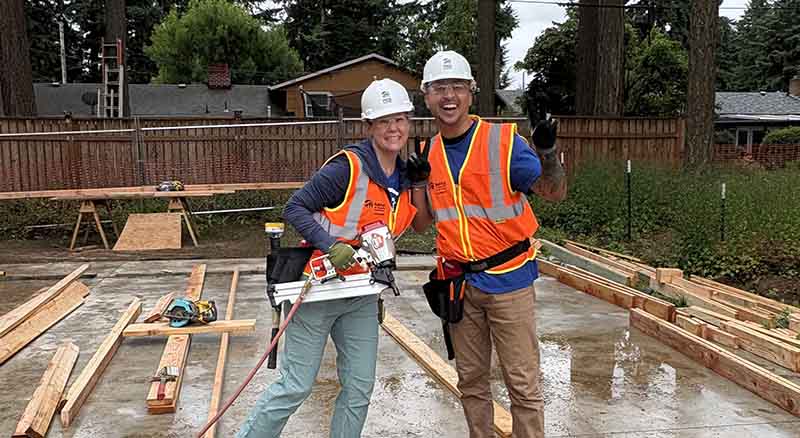 Two people volunteering at a home build project