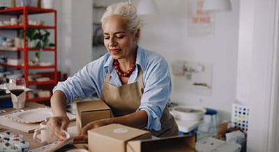 Person packing up pottery in shop