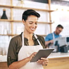 Coffeshop owner checks accounts on tablet