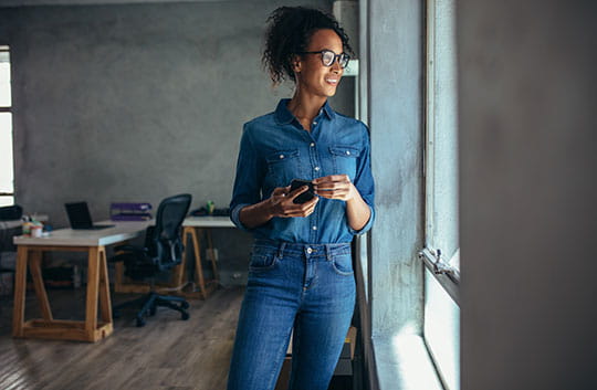 Business woman in jeans holding cell phone