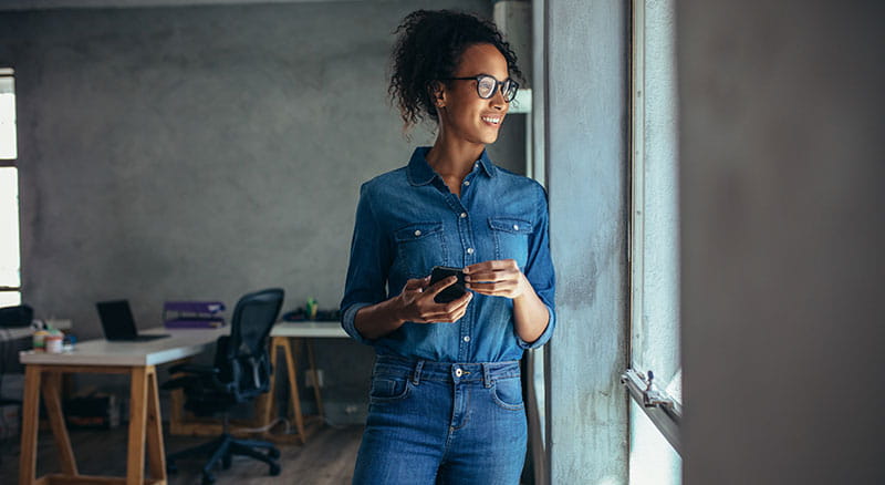 Business woman in jeans holding cell phone