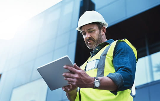 Building contractor or owner on tablet