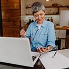 Person looking at phone while at a computer