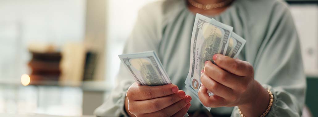 Person counting $100 bills Person counting $100 bills