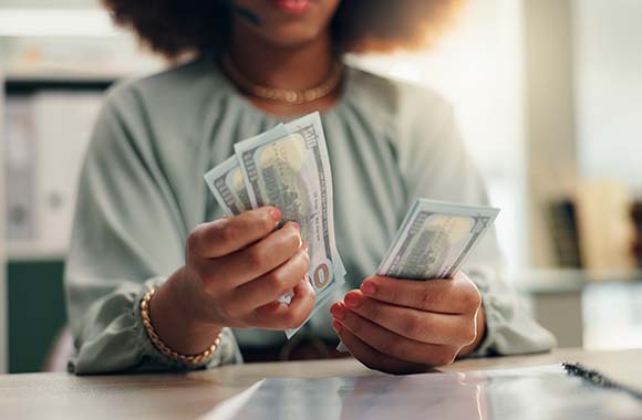 Person counting $100 bills Person counting $100 bills