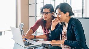 Two people looking at a computer in an office