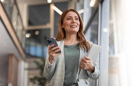 Person walking an office holding a cell phone