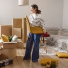 A woman holding a chair in a room with boxes