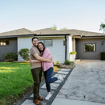 Happy people in front of home