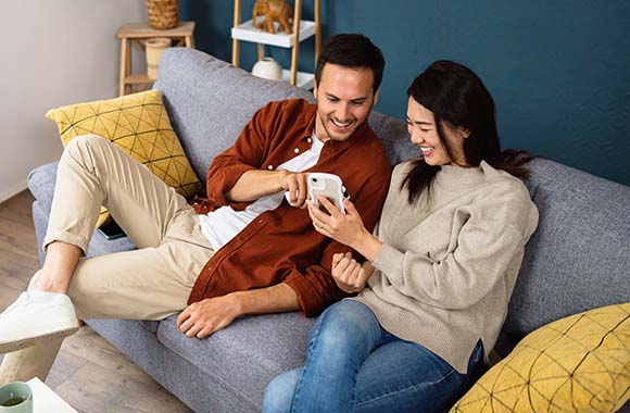 Two people on a couch looking at a phone