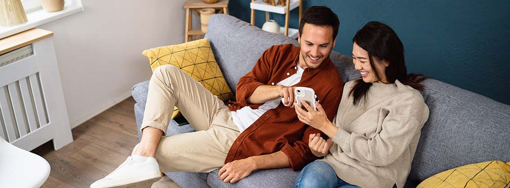 Two people on a couch looking at a phone