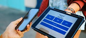 Person using a phone to pay on a tablet