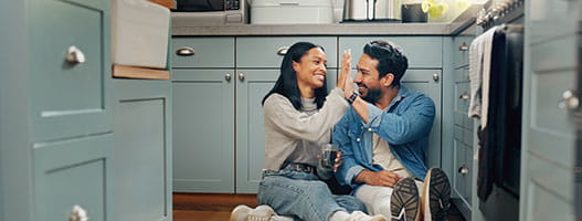 Two people high fiving on the kitchen floor