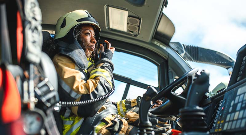 Firefighter talking into radio in a firetruck