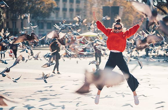 Person jumping while birds fly