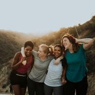 Four women hug while hiking