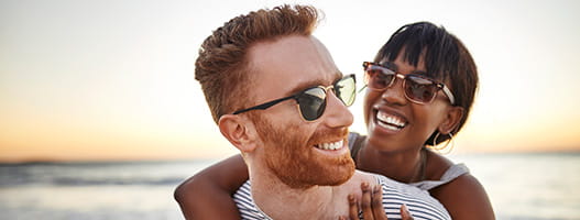 Two people smiling at the beach