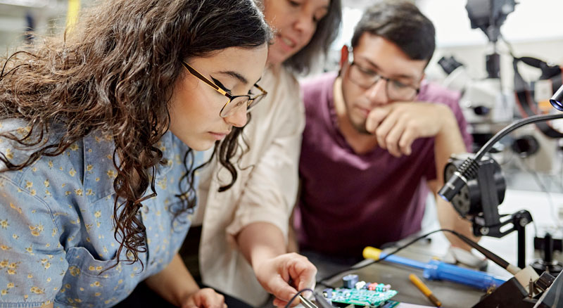 Professor helps college engineering students with electrical project