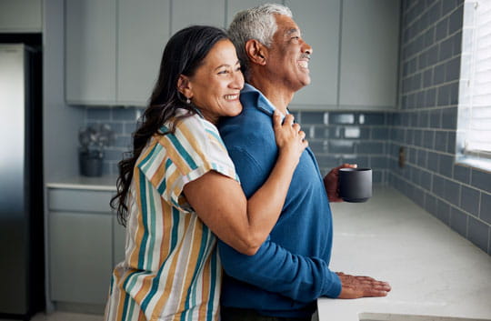 Happy older couple hugging while looking out window